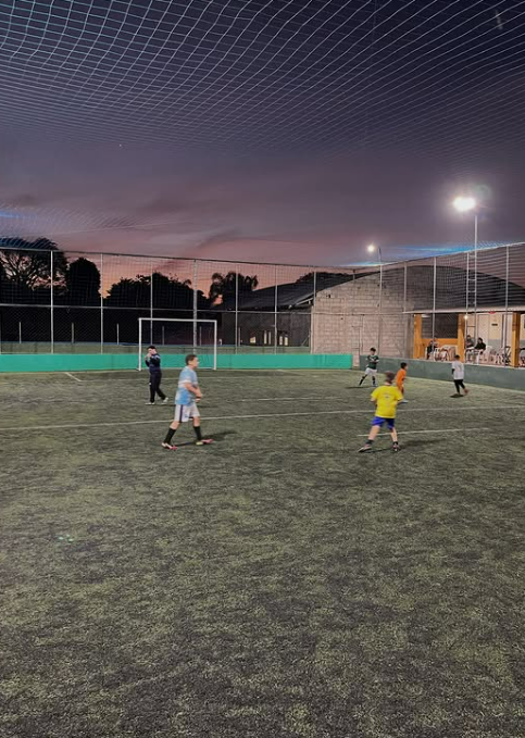 Campo society iluminado à noite no KM80 Esportes